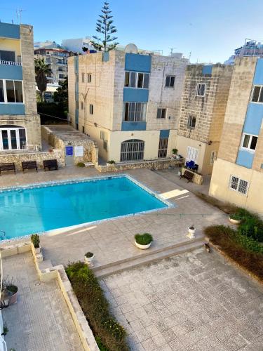 a large swimming pool in front of a building at Sea view home away from home in St. Paul's Bay