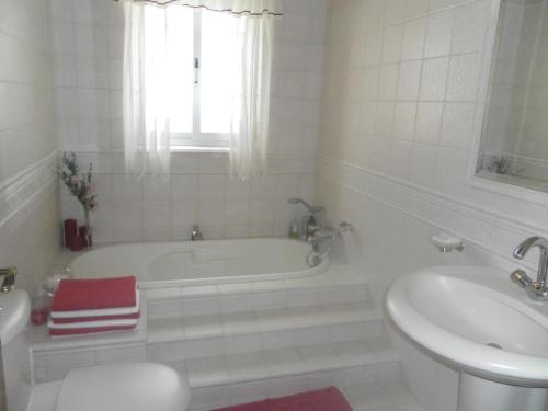 a white bathroom with a tub and a sink at Sea view home away from home in St. Paul's Bay