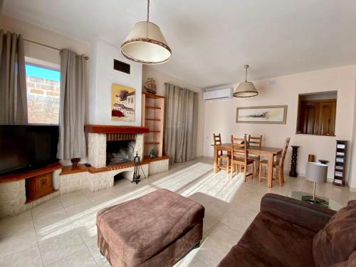 a living room with a fireplace and a dining room at Sea view home away from home in St. Paul's Bay