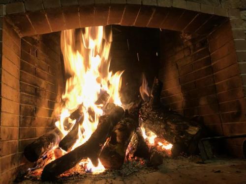 a brick fireplace with a fire in it at Anarada Guesthouse in Synikia Mesi Trikalon