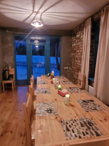 a large wooden table with chairs in a room at Darya Hostel Jyrgalan in Dzhergalan