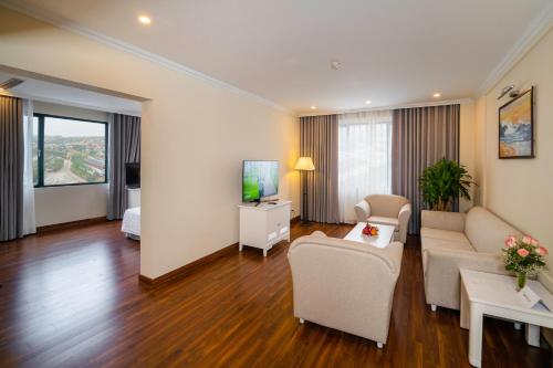 a living room with a couch and a tv at Ha Long Dream Hotel in Ha Long