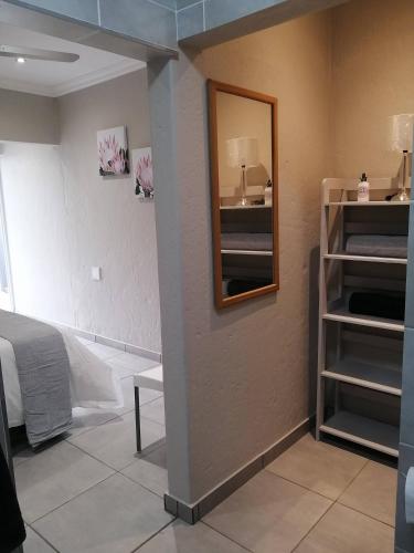 a room with a bed and a mirror on the wall at 394OnEmus in Pretoria