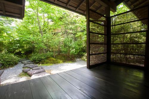 an outside view of a house with a wooden porch at Yufuin Bettei Itsuki in Yufuin