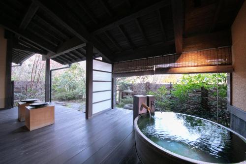 a bathroom with a tub in the middle of a room at Yufuin Bettei Itsuki in Yufuin