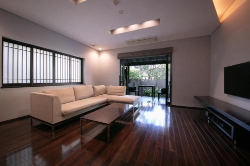 a living room with a couch and a tv at Yufuin Bettei Itsuki in Yufuin