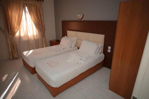 a bedroom with a bed with white sheets and pillows at Hotel Konti in Korçë