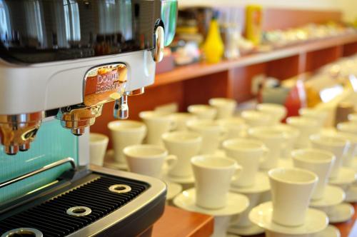 a coffee machine sitting on a table with cups at Penzion Krumlov - Massage studio in Český Krumlov