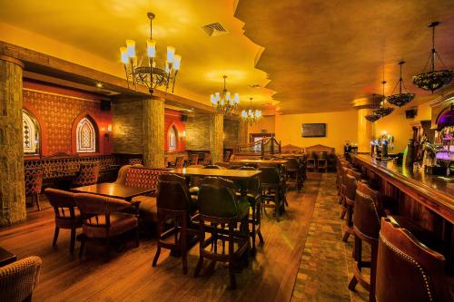 a restaurant with tables and chairs and a bar at Errigal Country House Hotel in Cootehill