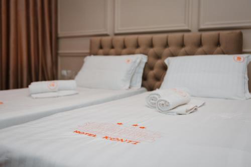 a hotel room with two beds with white sheets at Hotel Konti in Korçë