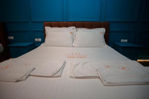 a bed with white sheets and towels on it at Hotel Konti in Korçë