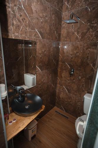a bathroom with a black sink and a toilet at Hotel Konti in Korçë