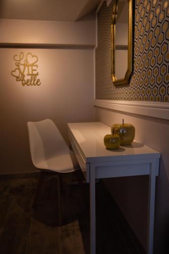 a table with a white chair and a table with fruit on it at Le Refuge in Namur