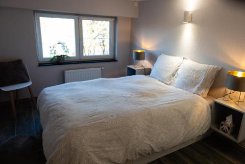 a bedroom with a white bed and a window at Le Refuge in Namur