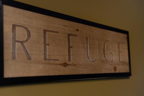 a wooden sign with the word rise on a wall at Le Refuge in Namur