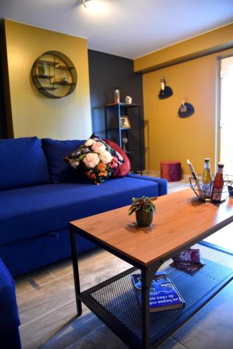 a living room with a blue couch and a wooden table at Le Refuge in Namur
