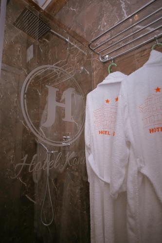 a couple of white shirts hanging on a rack at Hotel Konti in Korçë