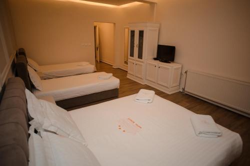 a small room with two beds and a television at Hotel Konti in Korçë
