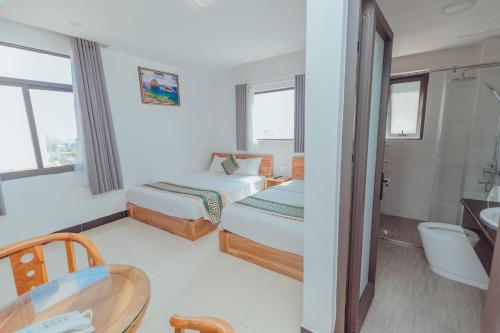 Habitación de hotel con 2 camas y mesa en Luxury hotel Phú Yên, en Liên Trì (3)