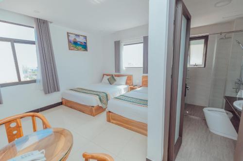 a hotel room with two beds and a table at Luxury hotel Phú Yên in Liên Trì (3)