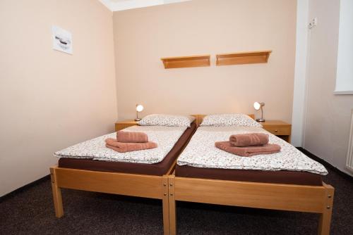 two beds in a room with two towels on them at PENZION MAXIM in Třeboň