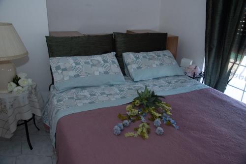 een slaapkamer met een bed met een bloemstuk erop bij 'Panta rei' in Mentana