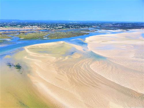 an aerial view of sand dunes on a beach at Apartamento Praia Fuseta 3 - Ria Formosa in Olhão