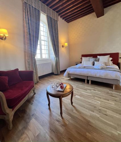 a bedroom with a bed and a table and a couch at Chambres d'hôtes Relais Mira Peis in Mirepoix