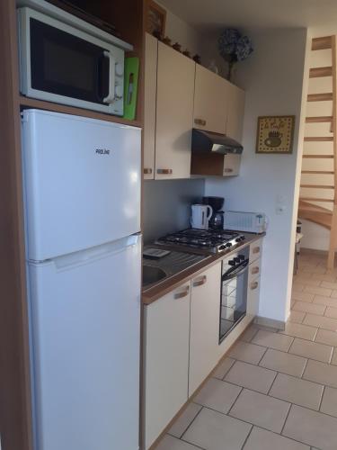 une cuisine avec un réfrigérateur et un micro-ondes dans l'établissement Gite les Grandes Masures Vasterival, à Varengeville-sur-Mer