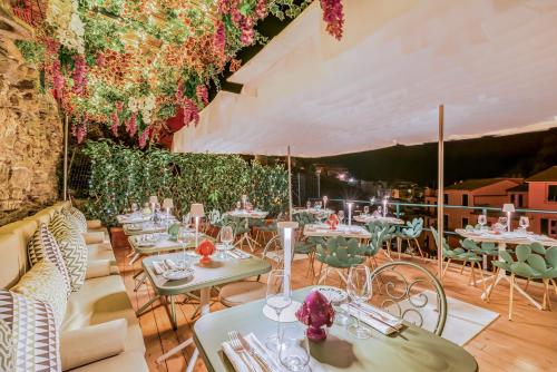 a restaurant with tables and chairs and flowers at Il Sogno di Manarola by The First in Manarola