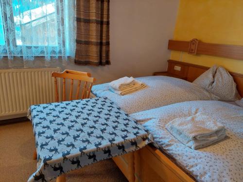1 dormitorio con 2 camas individuales y ventana en Ferienwohnung Muhlbauer en Wald im Pinzgau