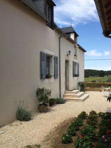 a white house with blue shuttered windows and plants at Gîte de l’enclos in Menetou-Râtel