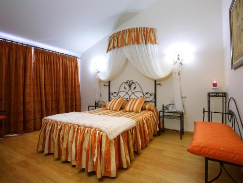 a bedroom with a large bed with an orange bedspread at Hotel El Juglar in Olite