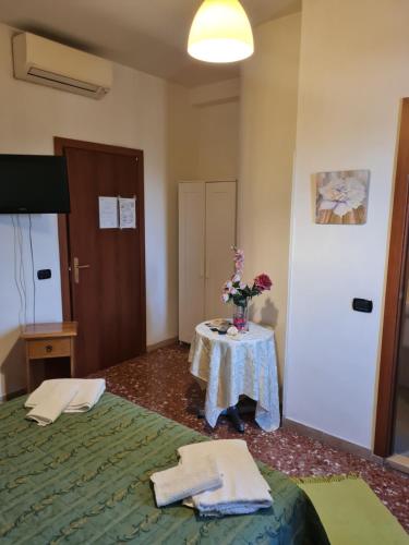 a room with a table with a bed and flowers on it at LA PALAZZINA in Rome