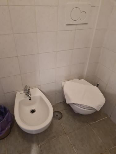 a bathroom with a white toilet and a sink at LA PALAZZINA in Rome