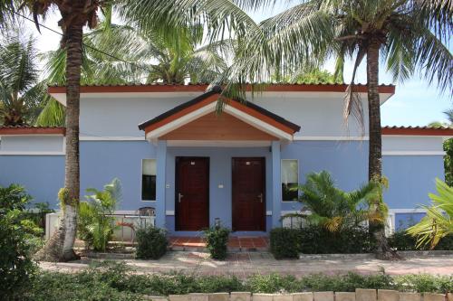a house with palm trees in front of it at Scarlet Sails Resort in Koh Rong Island