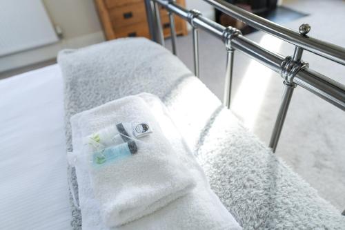 a bed with white towels on the side of it at Borrowfield Lodge in Derby
