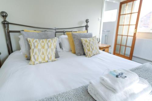 a bedroom with a white bed with towels on it at Borrowfield Lodge in Derby