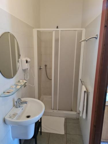 a white bathroom with a shower and a sink at LA PALAZZINA in Rome