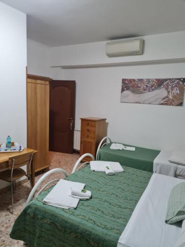a room with a bed and a table with a green blanket at LA PALAZZINA in Rome