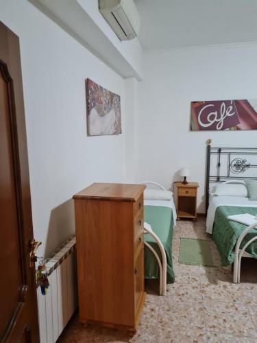 a room with two beds and a dresser in it at LA PALAZZINA in Rome
