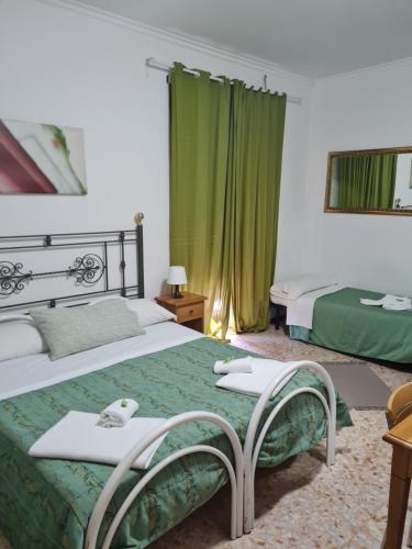 pokój hotelowy z 2 łóżkami i zielonymi zasłonami w obiekcie LA PALAZZINA w Rzymie