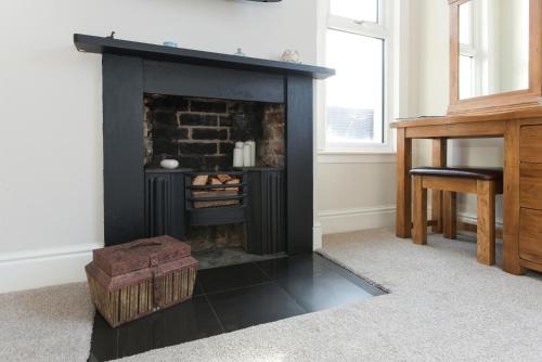 a black fireplace in a living room with a table at Borrowfield Lodge in Derby