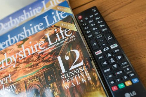 a book and a remote control on a table at Borrowfield Lodge in Derby