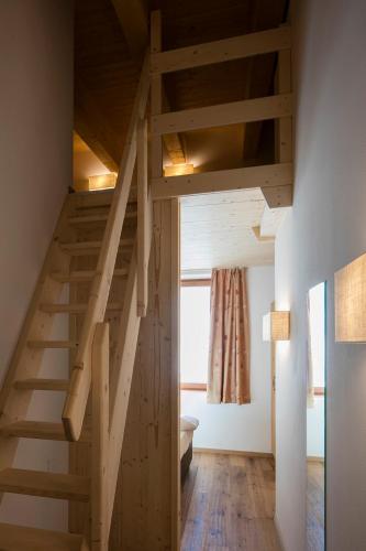 a wooden staircase in a room with a window at CAPANNA PRESENA in Passo del Tonale