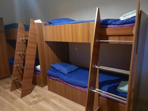 a room with three bunk beds with blue pillows at Brothers khutsishvili wine cellar in Kisiskhevi