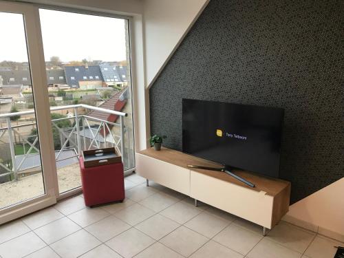 ein Wohnzimmer mit einem Flachbild-TV an der Wand in der Unterkunft De Wolfkes in Ostende