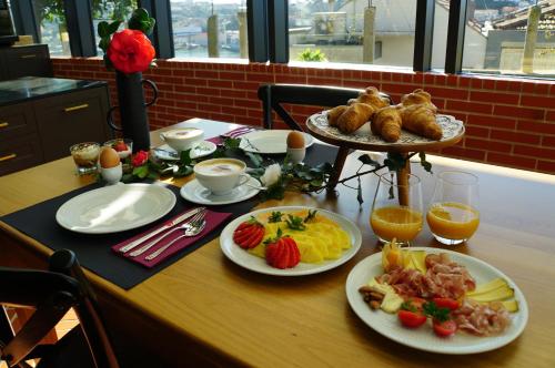 a table topped with plates of food and fruit at CASA CAMÉLIA in Porto