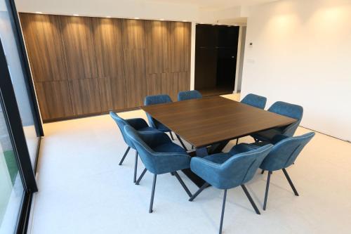 a conference room with a wooden table and blue chairs at VILLA MIAMI in Les Issambres