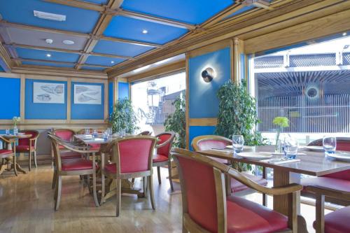 a restaurant with tables and chairs and a blue ceiling at II Castillas Madrid in Madrid